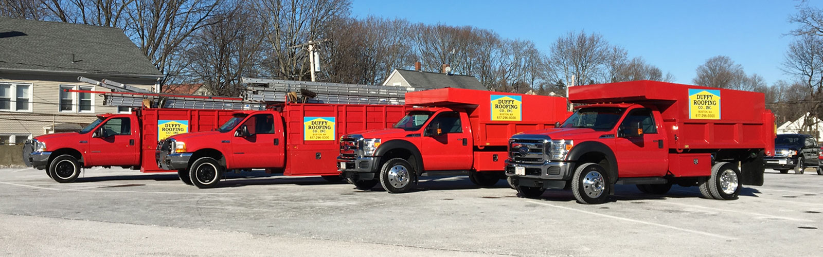 Duffy Roofing Co., Inc. red work trucks lined up in a row in a parking lot